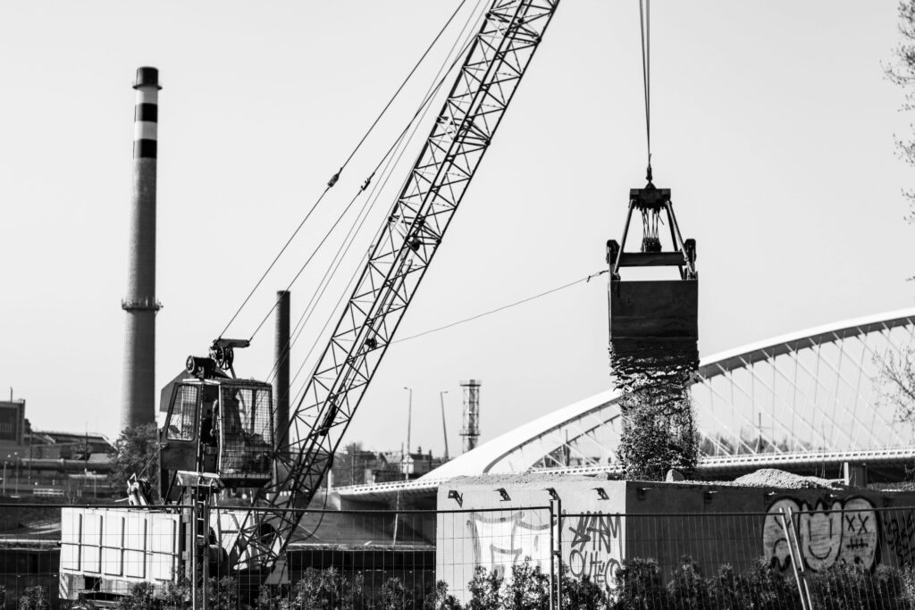 a crane lifting a large bucket of debris