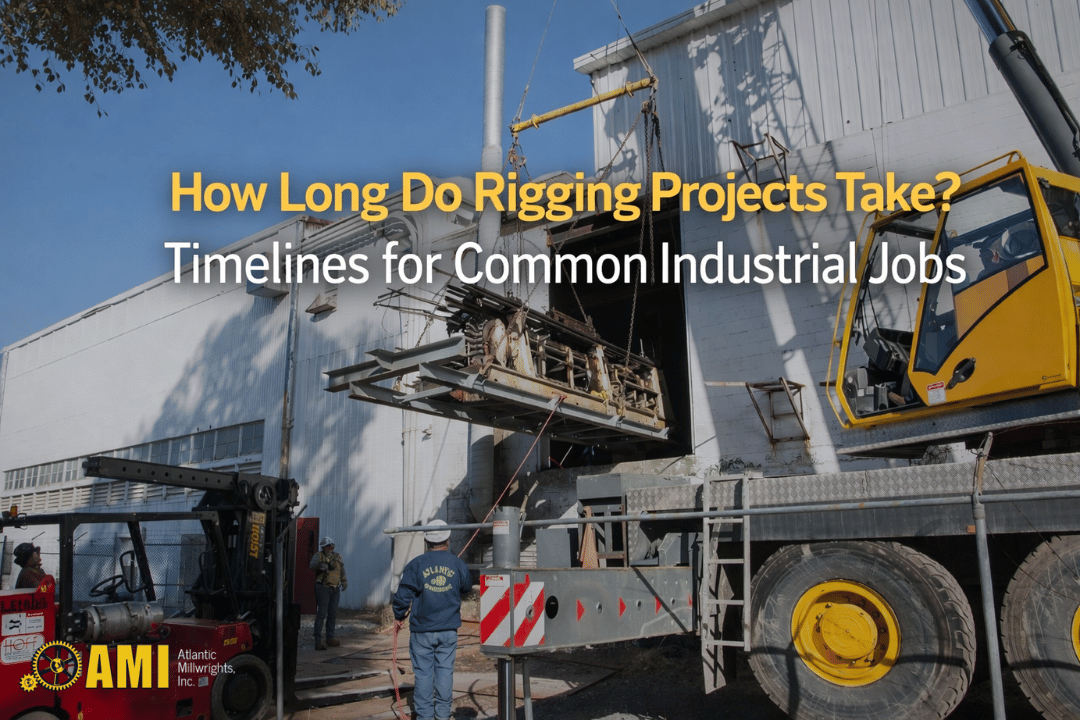 A crane and workers move industrial equipment outside a large building, illustrating rigging work for industrial projects.